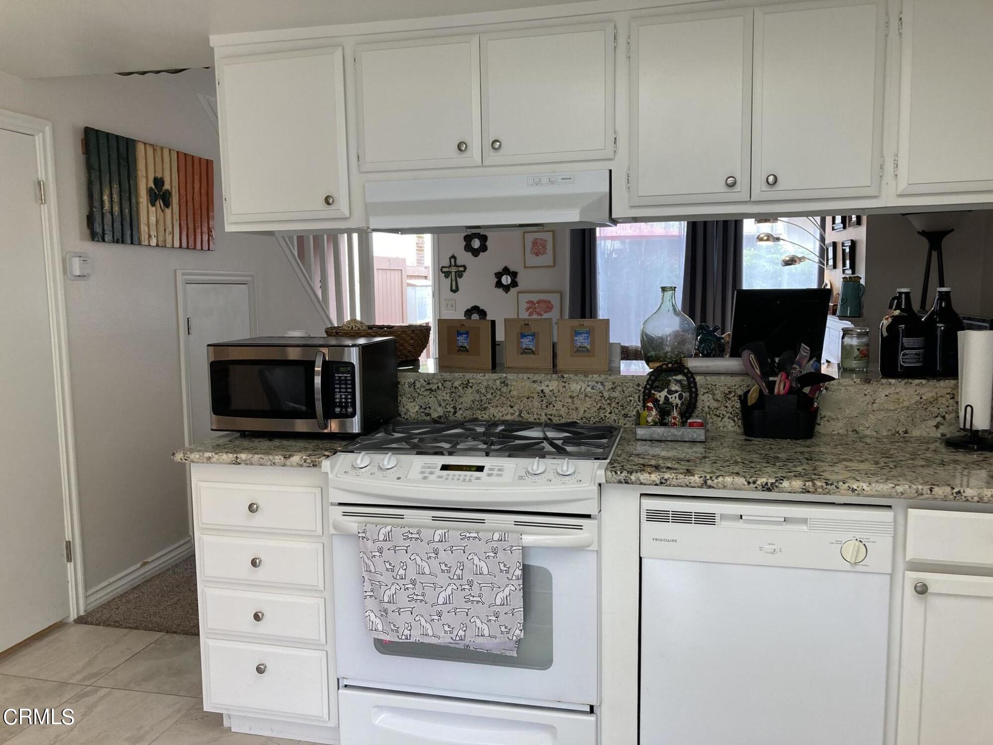 5130 West Wooley Road, Unit 2 Oxnard, CA 93035 - Photo 5 of 11 a kitchen with stainless steel appliances granite countertop a stove a sink and a microwave