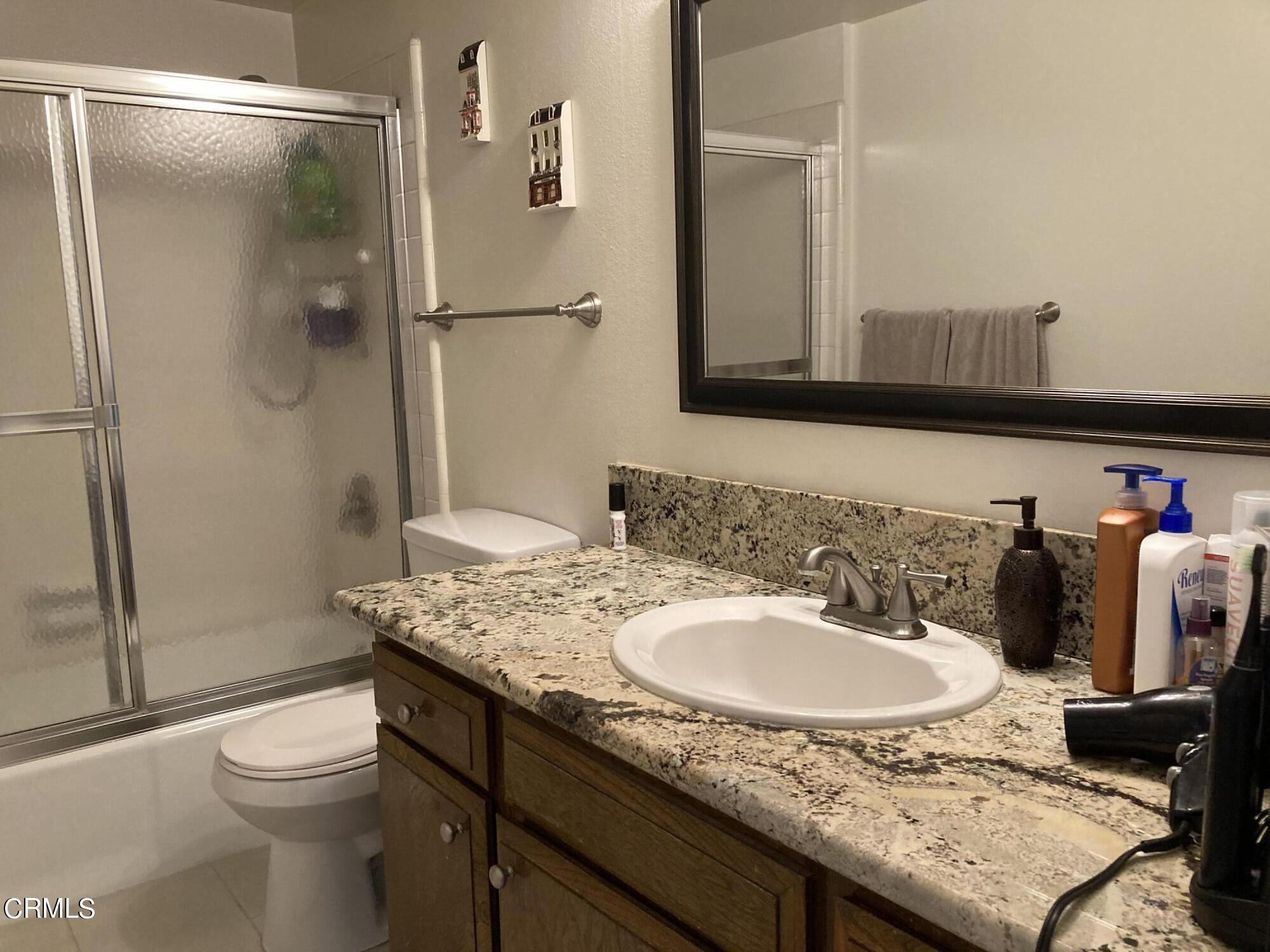 5130 West Wooley Road, Unit 2 Oxnard, CA 93035 - Photo 9 of 11 a bathroom with a granite countertop sink toilet and shower