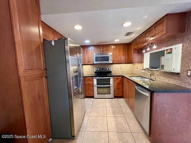 a kitchen with stainless steel appliances granite countertop a refrigerator and a stove top oven
