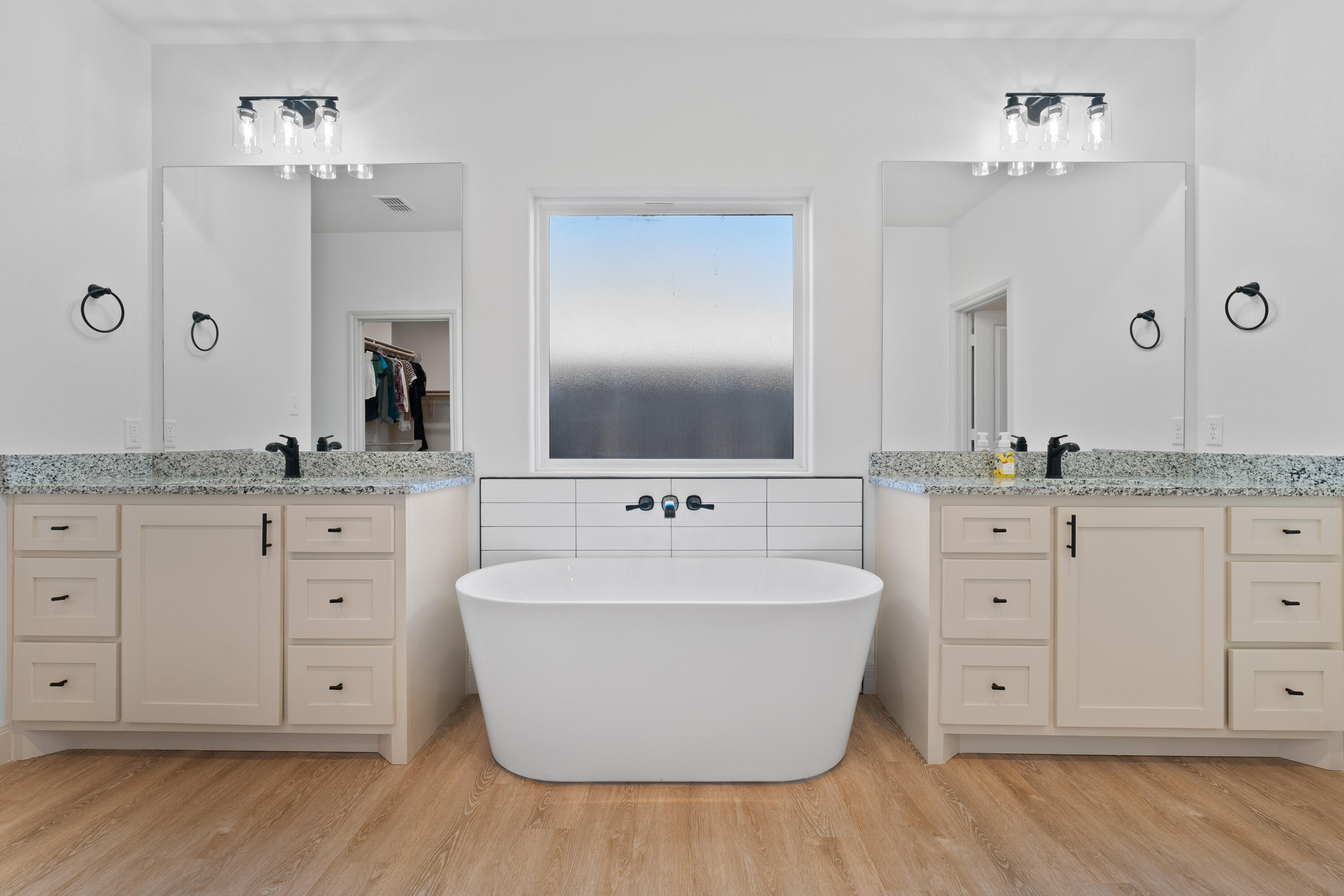 5516 120th Street Lubbock, TX 79424 - Photo 18 of 34 a spacious bathroom with double vanity sink a two mirror a window and a bathtub