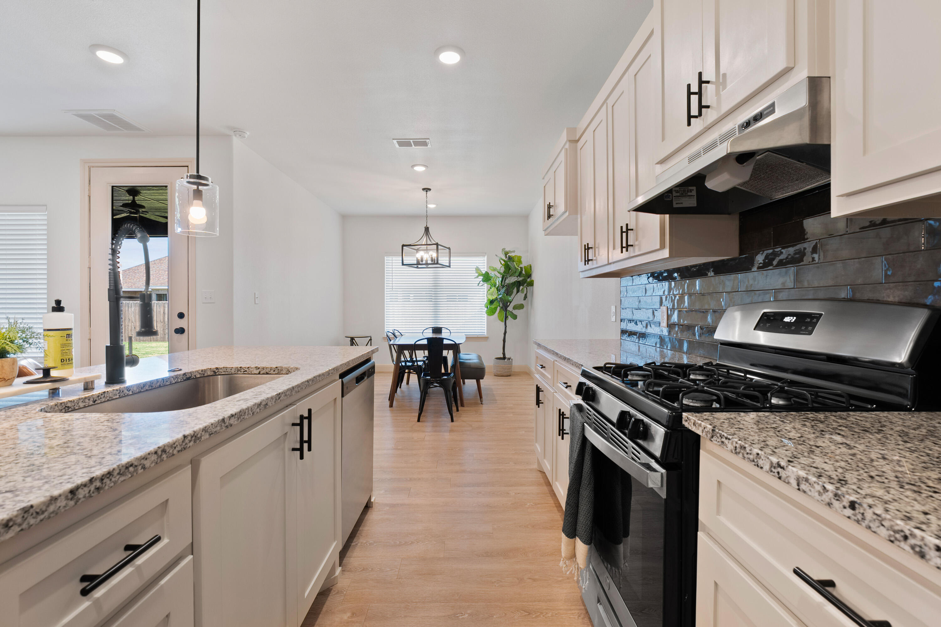 5516 120th Street Lubbock, TX 79424 - Photo 10 of 30 a kitchen with stainless steel appliances granite countertop a stove a sink a refrigerator and a wooden cabinets