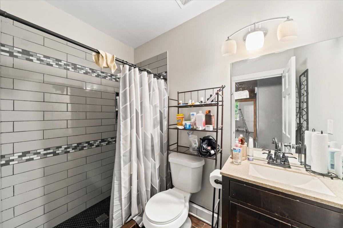 196 North McNeil Street Memphis, TN 38112 - Photo 29 of 31 a bathroom with a sink a toilet a mirror and shower