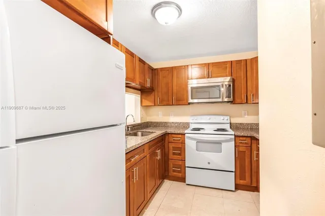 a kitchen with stainless steel appliances granite countertop a sink a microwave cabinets and a counter top space