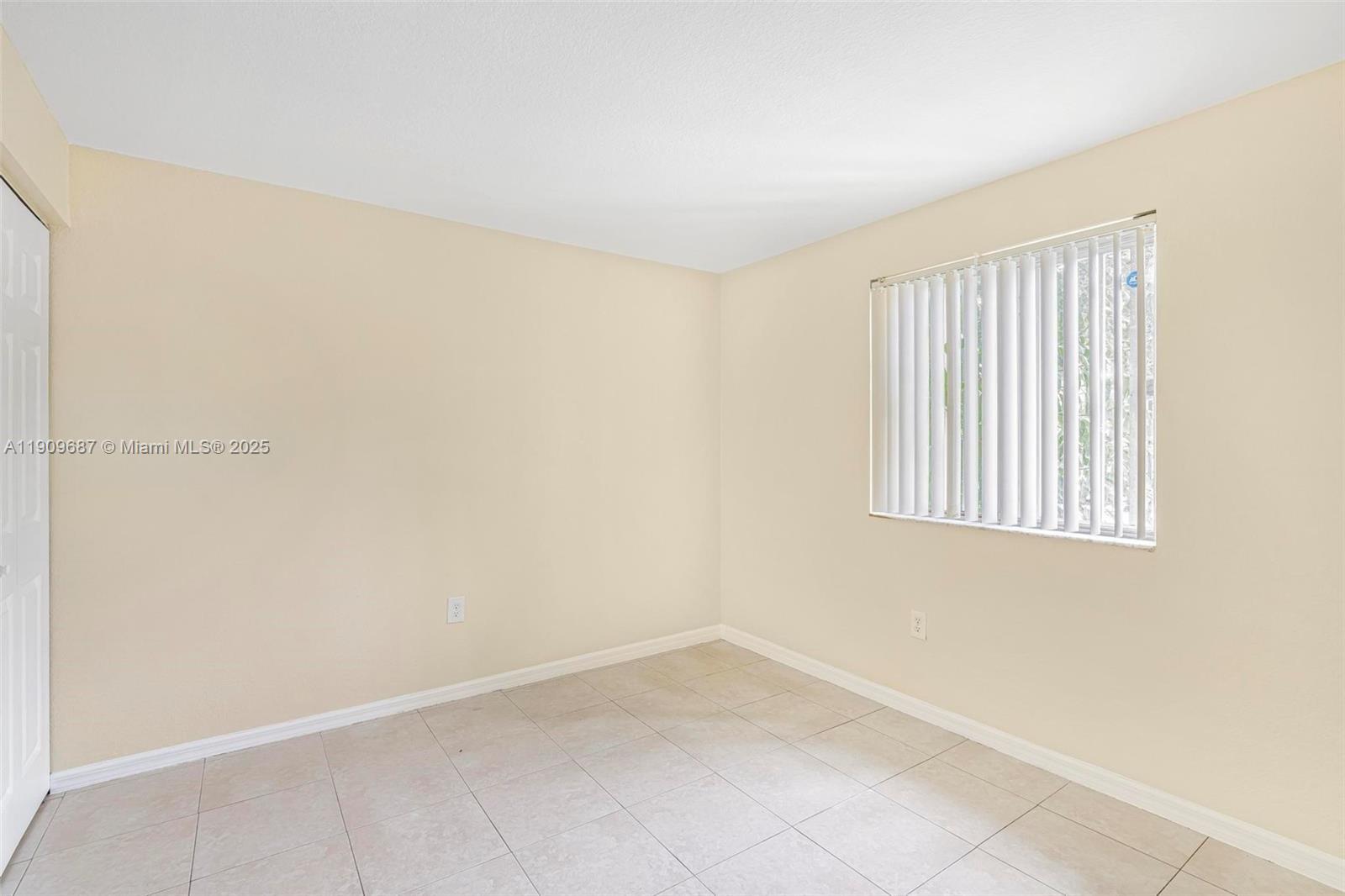 2261 Northwest 136th Terrace, Unit 2261 Opa-Locka, FL 33054 - Photo 8 of 19 a view of an empty room with a window
