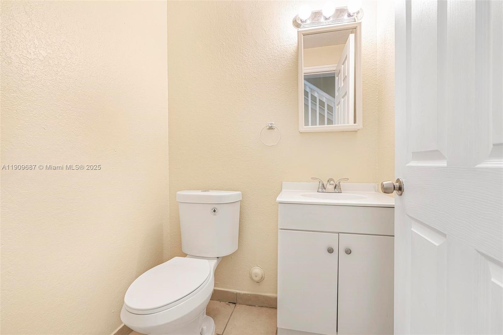 2261 Northwest 136th Terrace, Unit 2261 Opa-Locka, FL 33054 - Photo 9 of 19 a white toilet sitting next to a bathroom sink