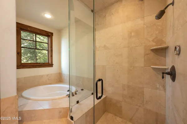 a spacious bathroom with a tub sink and mirror