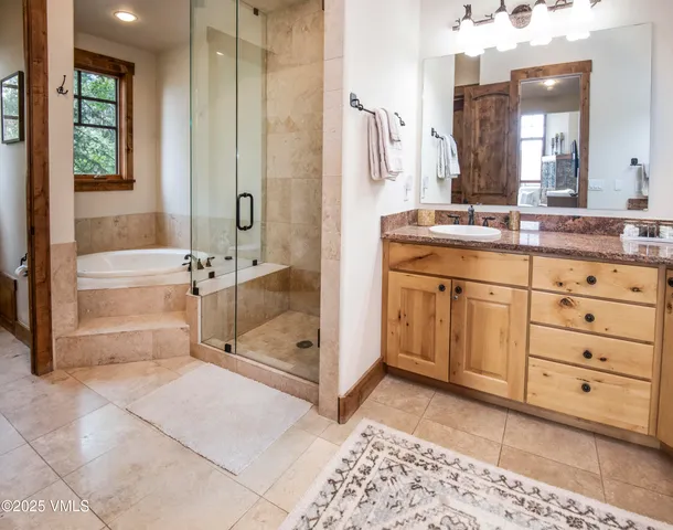 a spacious bathroom with a tub sink and mirror
