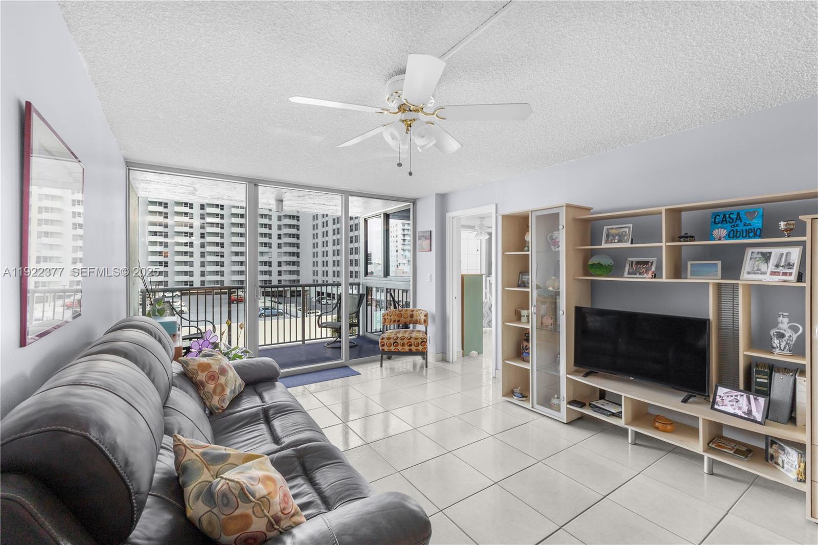 2655 Collins Avenue, Unit 603 Miami Beach, FL 33140 - Photo 11 of 66 a living room with furniture a flat screen tv and floor to ceiling window
