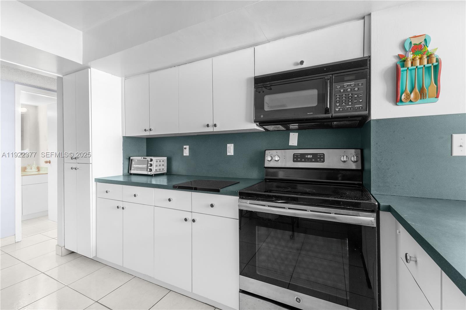 2655 Collins Avenue, Unit 603 Miami Beach, FL 33140 - Photo 22 of 66 a kitchen with stainless steel appliances granite countertop a stove and a microwave
