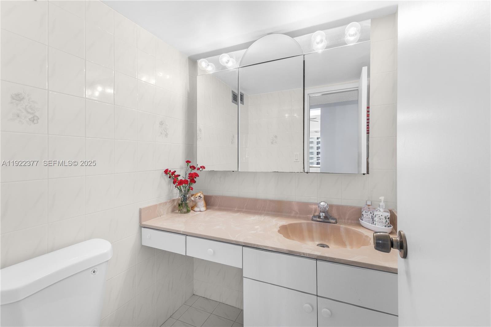 2655 Collins Avenue, Unit 603 Miami Beach, FL 33140 - Photo 30 of 66 a bathroom with a sink toilet and a mirror
