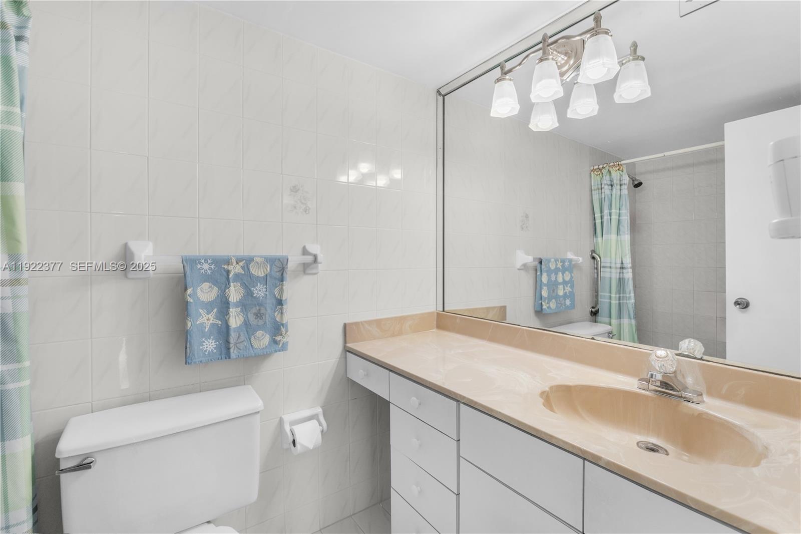 2655 Collins Avenue, Unit 603 Miami Beach, FL 33140 - Photo 35 of 66 a bathroom with a sink a toilet and a mirror