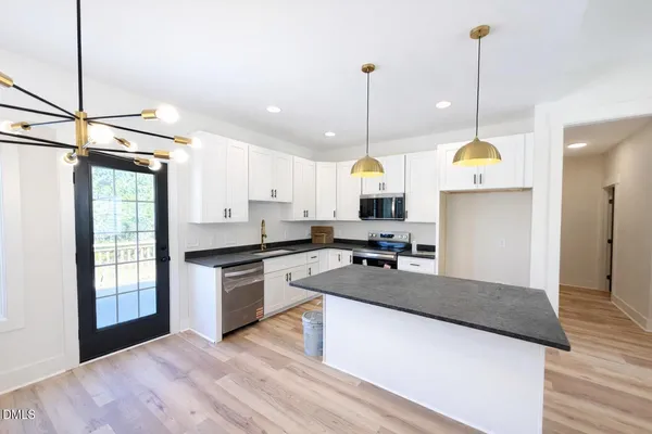 a view of a kitchen with a sink and stainless steel appliances
