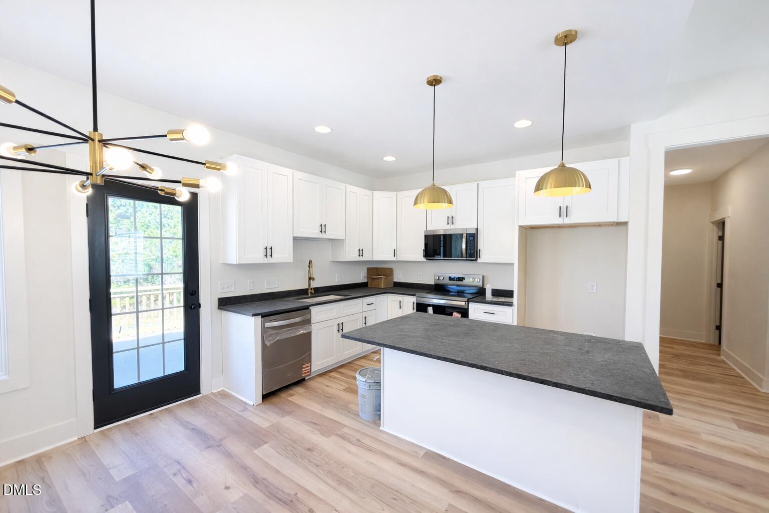 390 Park Springs Road Providence, NC 27315 - Photo 5 of 14 a kitchen with kitchen island granite countertop a stove a sink a center island a sink and a wooden floor