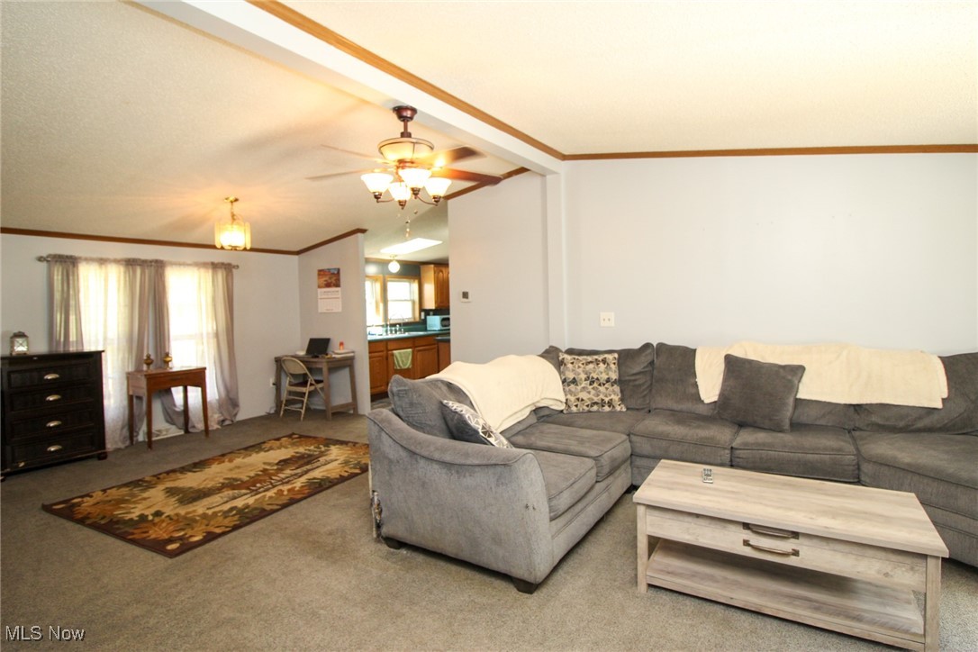 1798 Campbell Road Southwest New Philadelphia, OH 44663 - Photo 33 of 50 Living room featuring carpet, vaulted ceiling, and ceiling fan