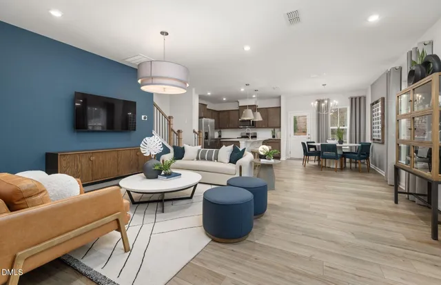 a living room with furniture a flat screen tv and kitchen view