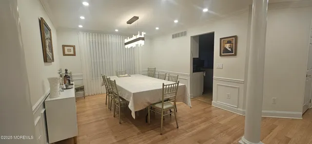 a view of a a dining room with furniture window and wooden floor