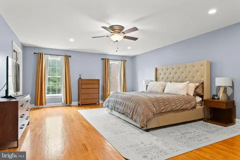 a spacious bedroom with a large bed and a flat tv screen