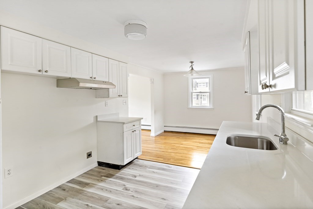 43 George Road, Unit 43 Winchester, MA 01890 - Photo 7 of 19 a kitchen with kitchen island a sink a stove and white cabinets