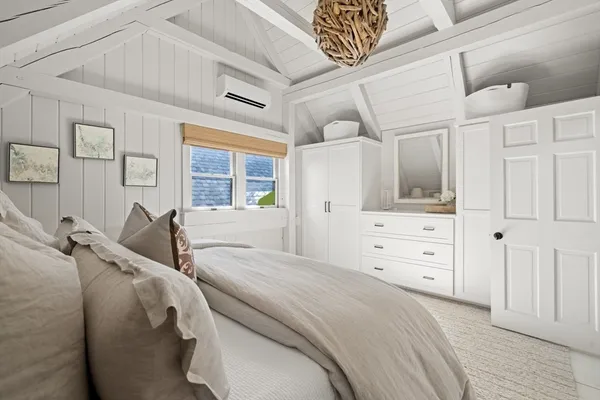 a bedroom with a bed and a large window