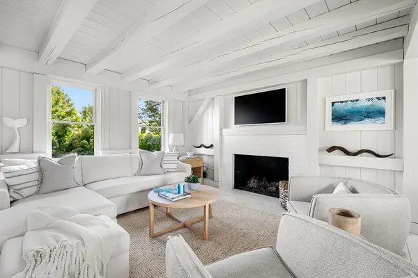 a living room with furniture a flat screen tv and a fireplace
