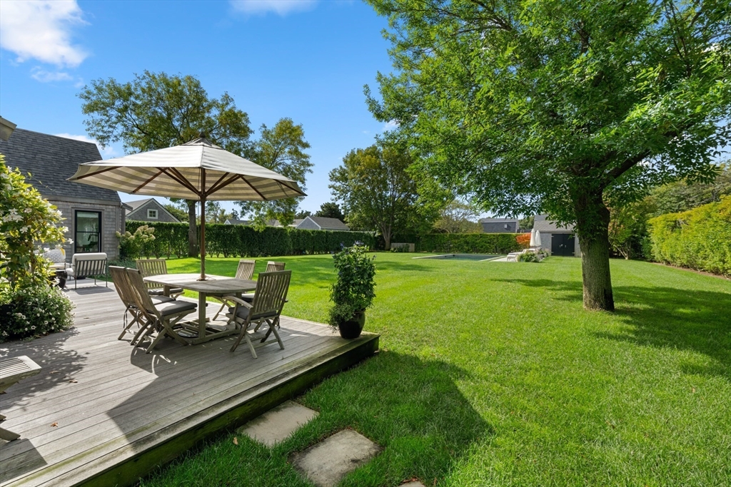 1 Doc Ryder Drive Nantucket, MA 02554 - Photo 39 of 42 a view of a table and chairs under an umbrella in backyard