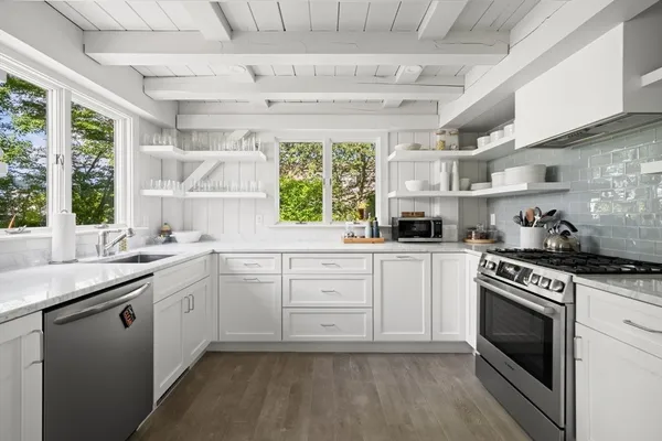 a kitchen with a stove a sink and a window