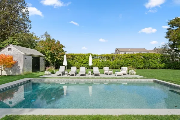 a view of backyard with swimming pool and outdoor seating