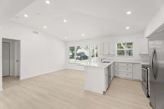 a kitchen with white cabinets and stainless steel appliances