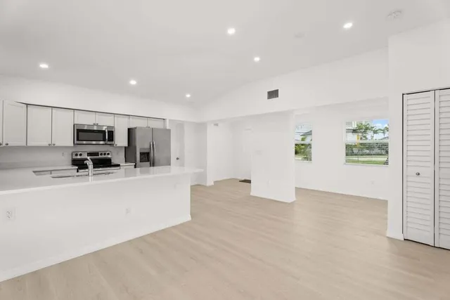 a view of kitchen with furniture and a refrigerator
