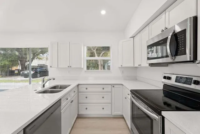 a kitchen with granite countertop cabinets stainless steel appliances and a sink