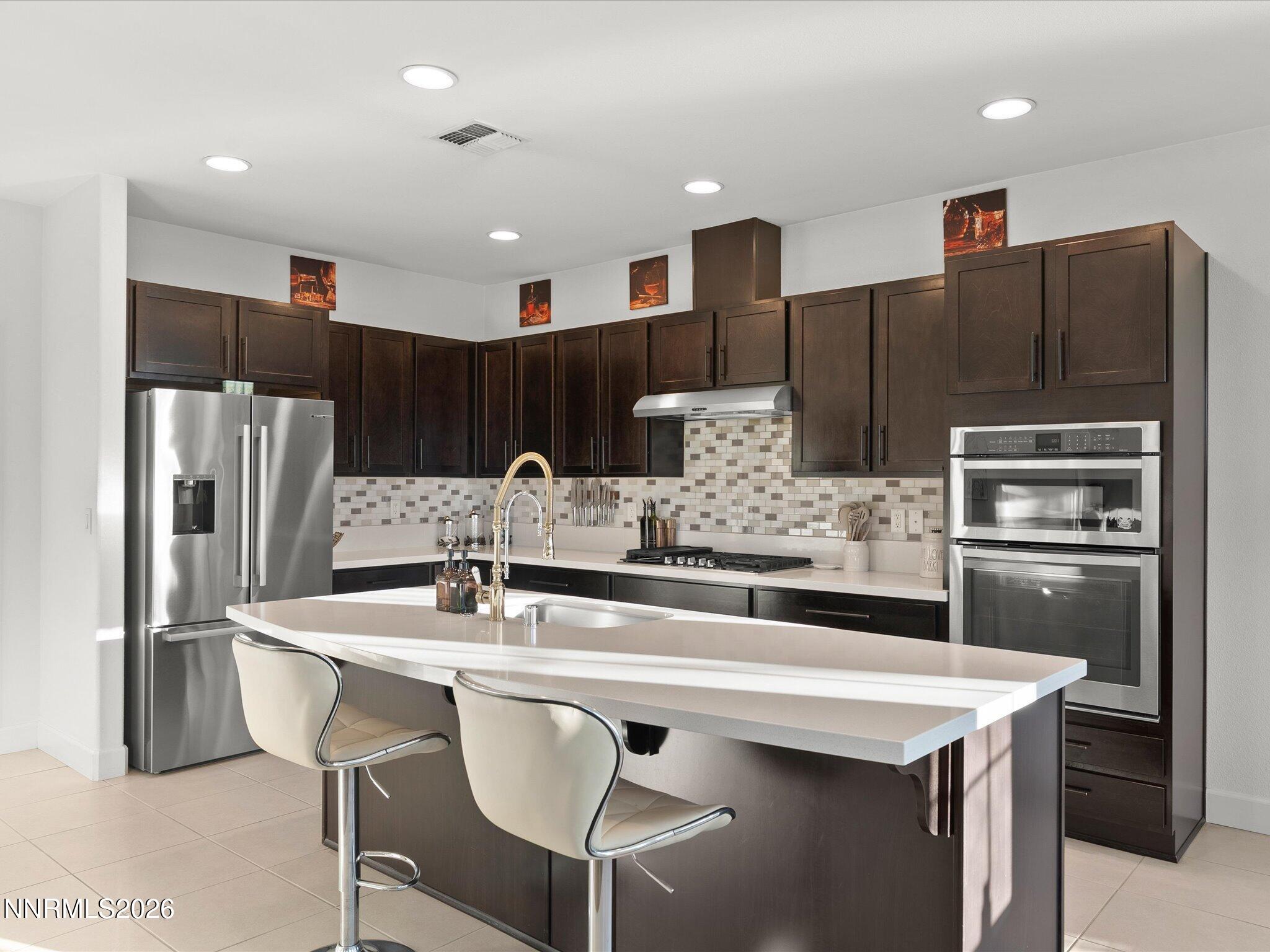9803 Ash Meadow Drive Reno, NV 89521 - Photo 17 of 56 a kitchen with stainless steel appliances kitchen island a refrigerator and a sink