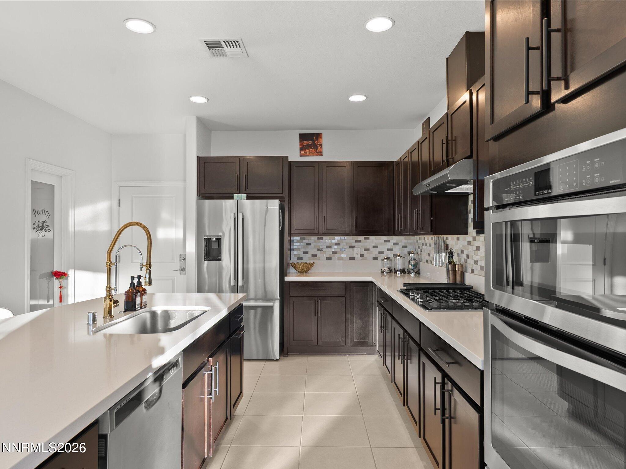 9803 Ash Meadow Drive Reno, NV 89521 - Photo 19 of 56 a kitchen with stainless steel appliances a sink stove and cabinets