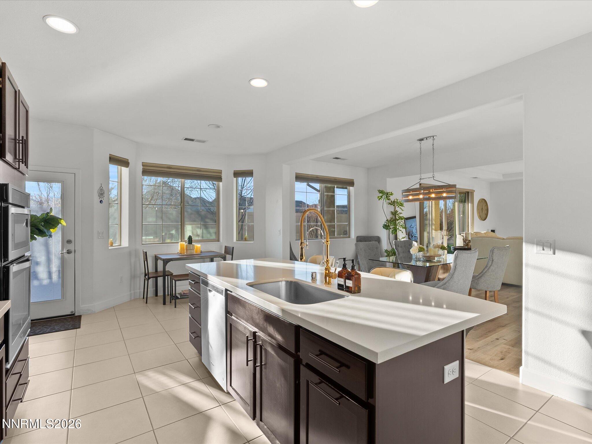 9803 Ash Meadow Drive Reno, NV 89521 - Photo 20 of 56 a kitchen with a counter top space a sink a counter space and living room view