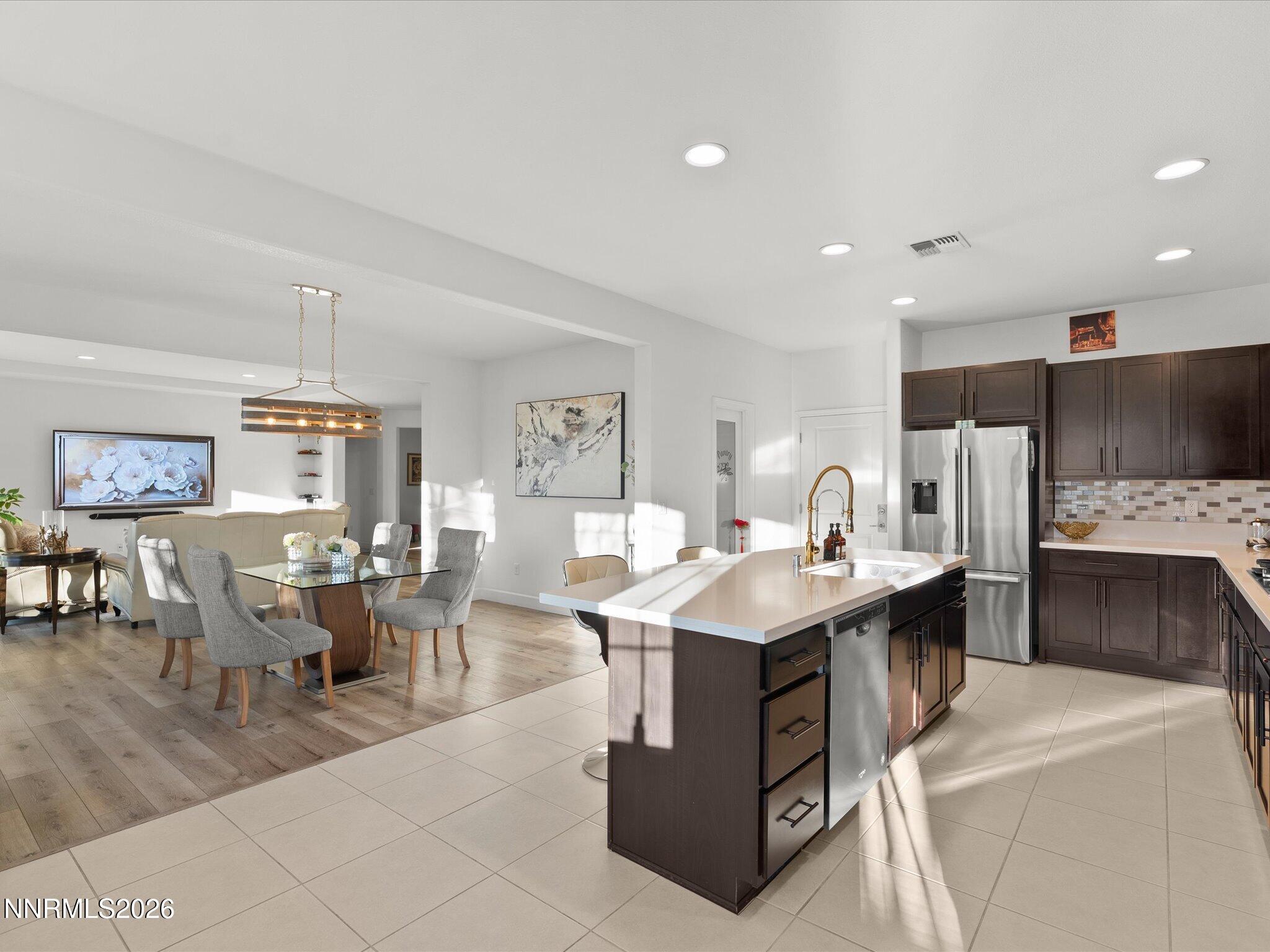 9803 Ash Meadow Drive Reno, NV 89521 - Photo 21 of 56 a living room with stainless steel appliances furniture a fireplace and a open kitchen view