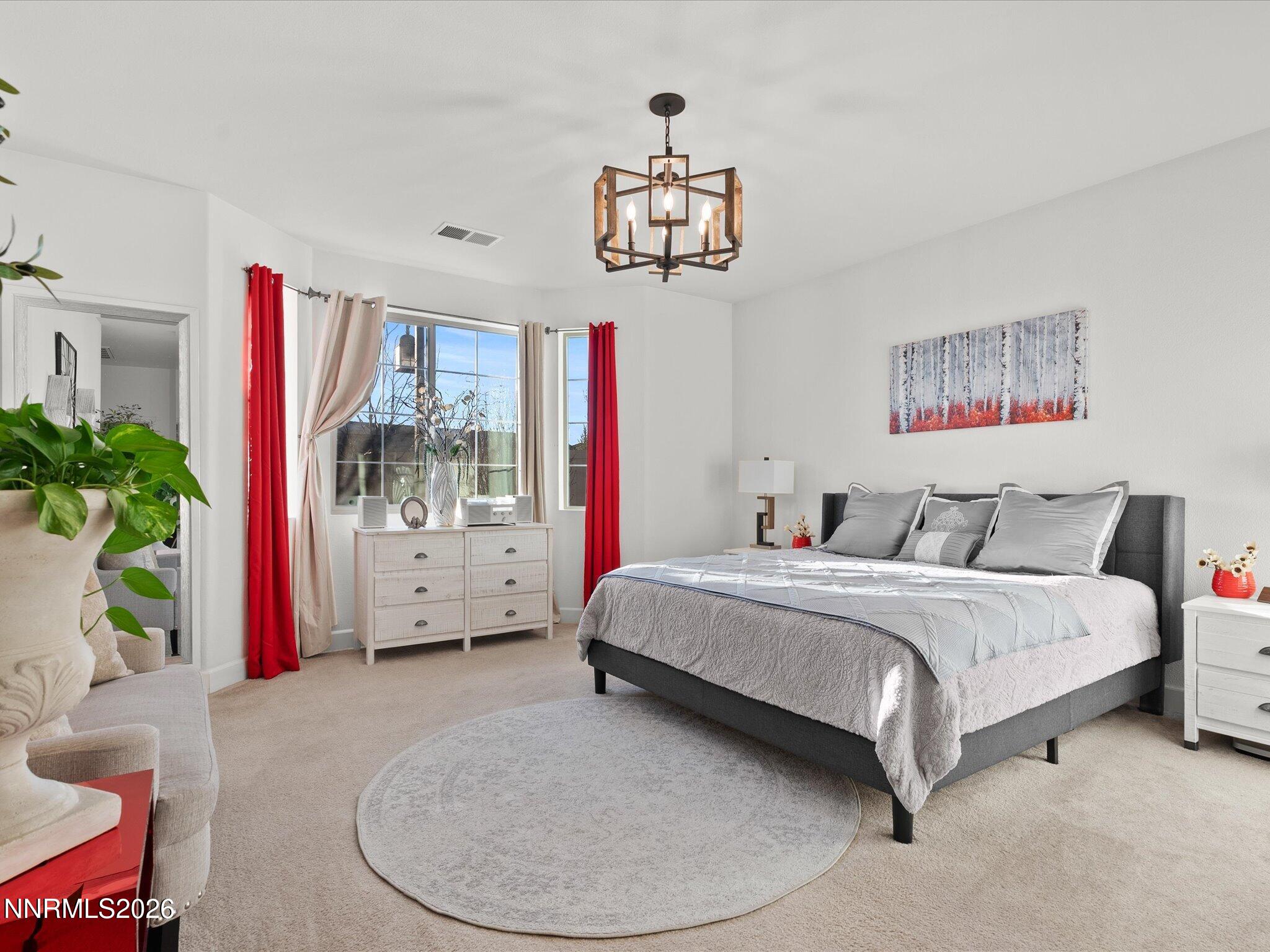 9803 Ash Meadow Drive Reno, NV 89521 - Photo 24 of 56 a spacious bedroom with a bed a couch and potted plant