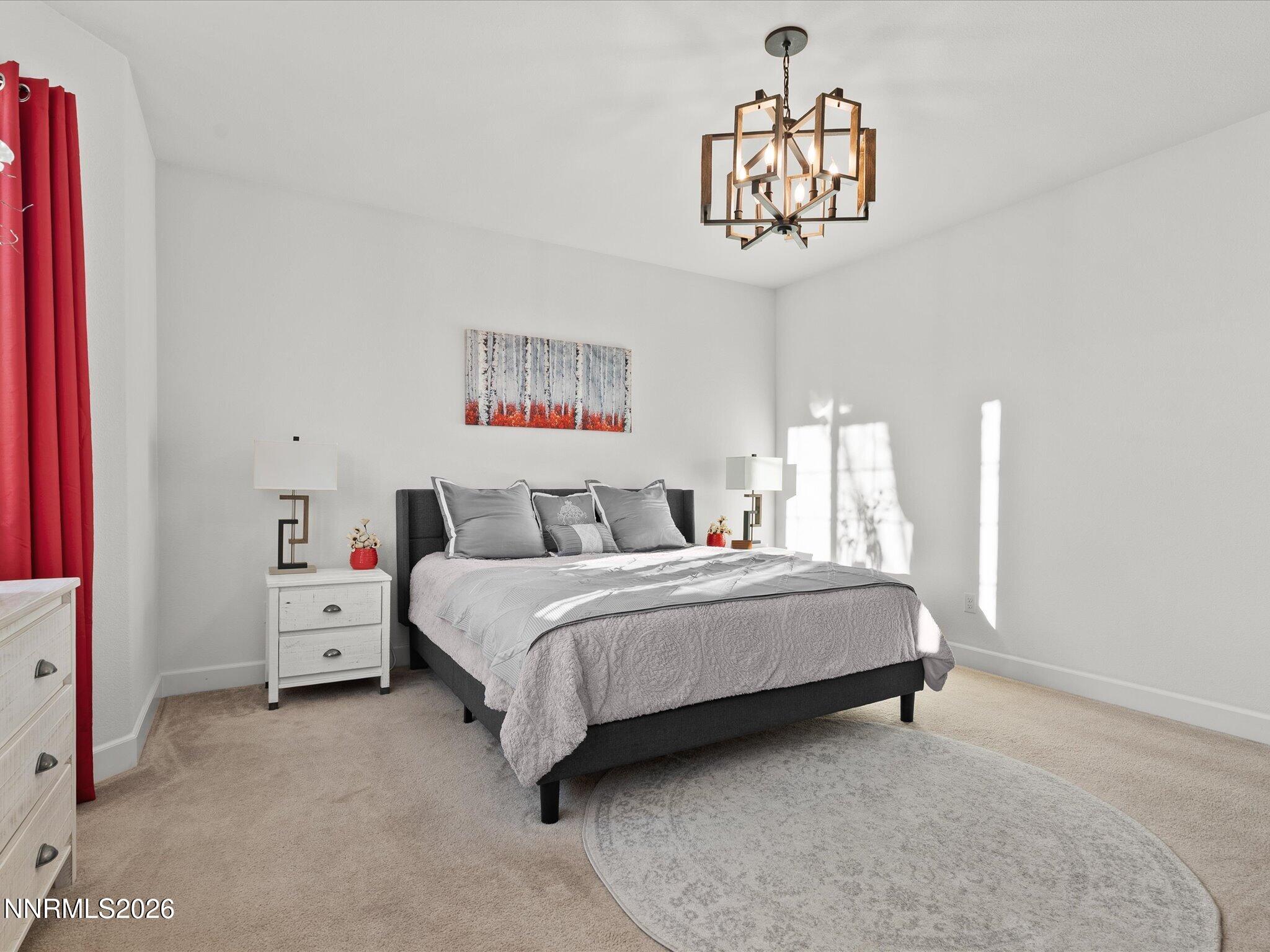 9803 Ash Meadow Drive Reno, NV 89521 - Photo 25 of 56 a spacious bedroom with a bed and a chandelier