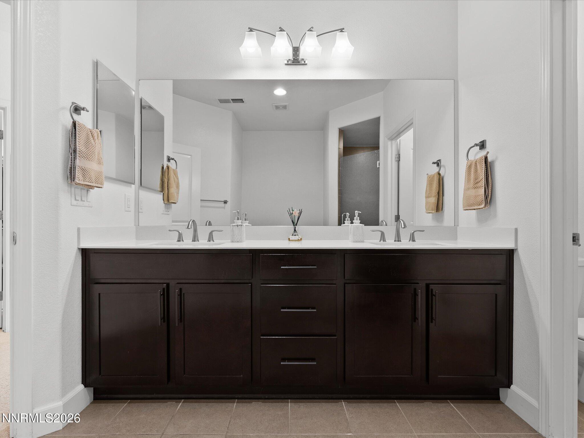 9803 Ash Meadow Drive Reno, NV 89521 - Photo 30 of 56 a bathroom with a double vanity sink and mirror