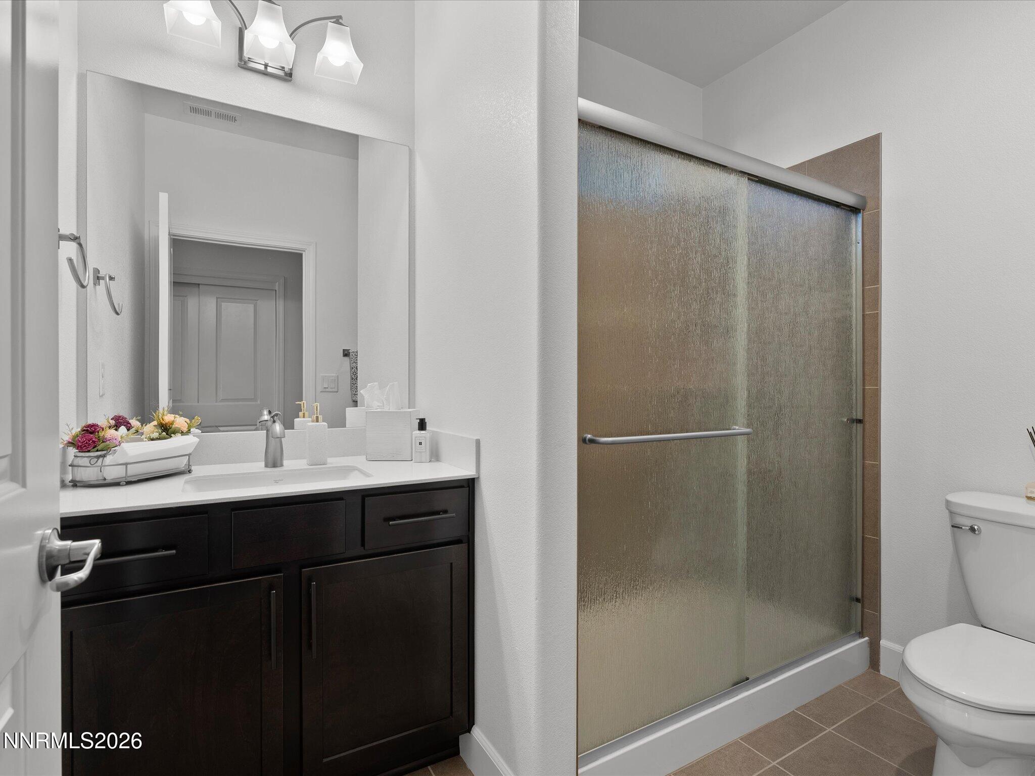 9803 Ash Meadow Drive Reno, NV 89521 - Photo 38 of 56 a bathroom with a shower sink vanity mirror and toilet