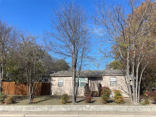 a view of a house with a tree next to a yard