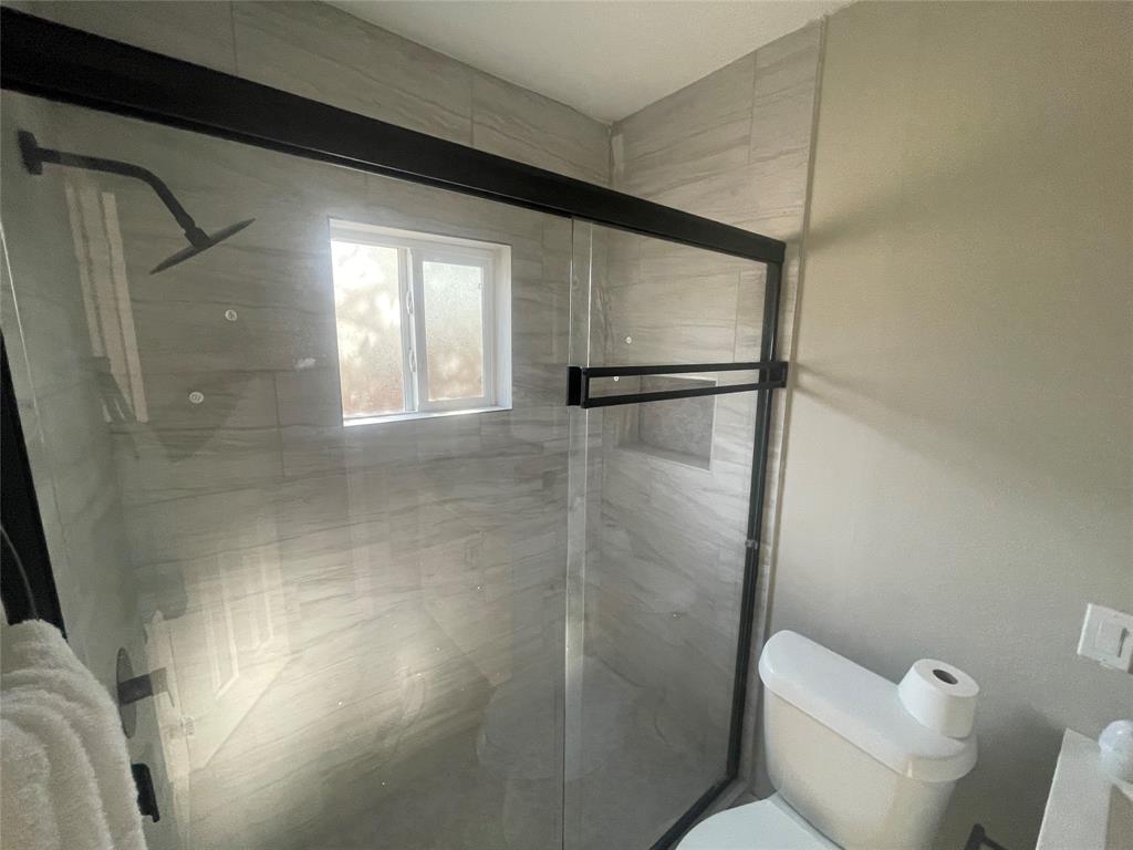 203 Broad Street McKinney, TX 75069 - Photo 13 of 19 a bathroom with a glass shower door