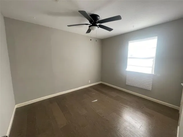 an empty room with a window and a ceiling fan
