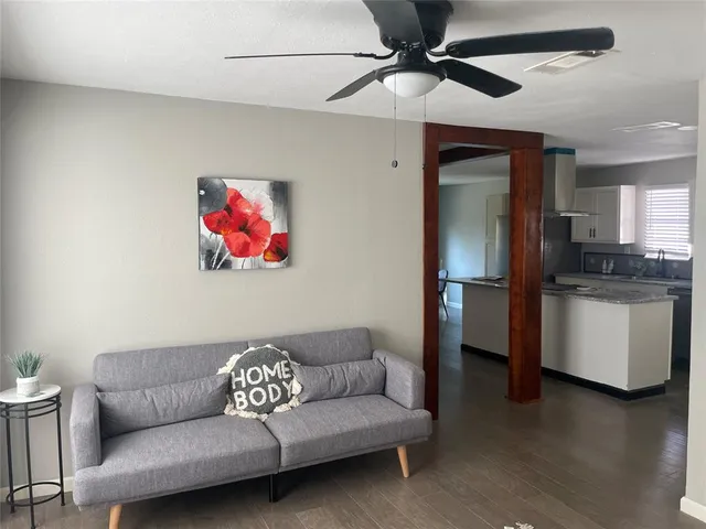 a living room with furniture and a ceiling fan