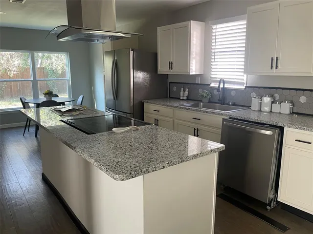 a kitchen with stainless steel appliances granite countertop a sink stove and refrigerator