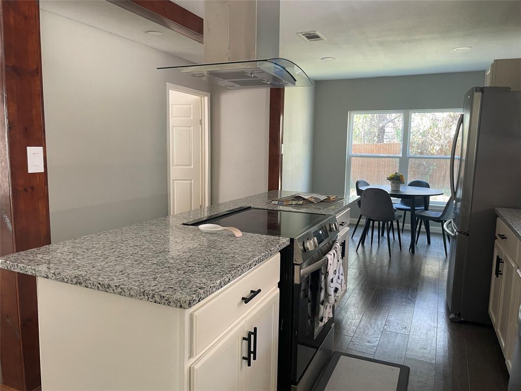203 Broad Street McKinney, TX 75069 - Photo 9 of 19 a kitchen with granite countertop kitchen island a table and a table in it