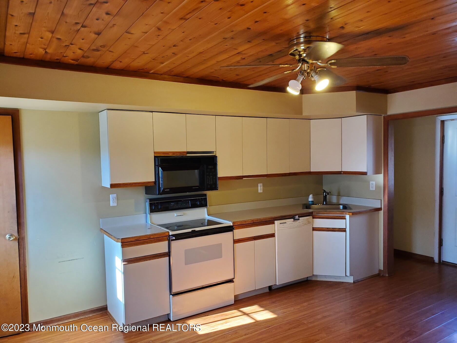 16 Pinewood Road Howell, NJ 07731 - Photo 14 of 28 a kitchen with stainless steel appliances a stove a microwave and a hard wood floor