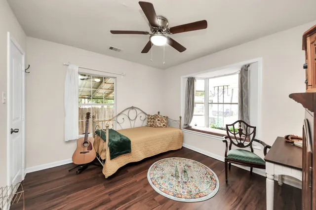 a view of a room with wooden floor lounge chair and windows