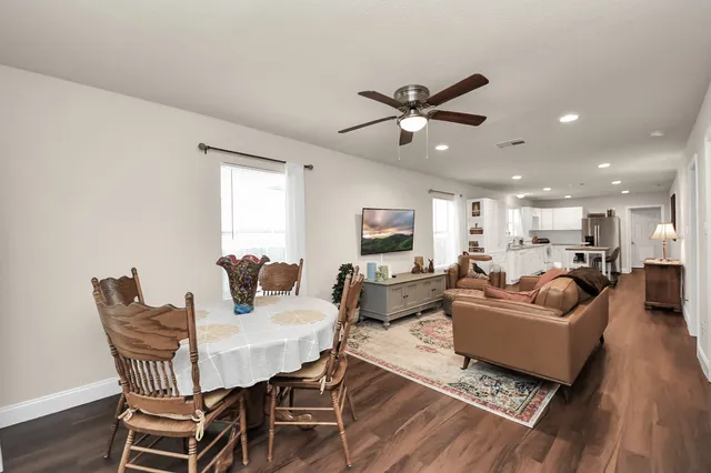 a living room with furniture a ceiling fan a rug and a window