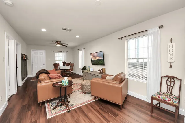 a living room with furniture rug and wooden floor