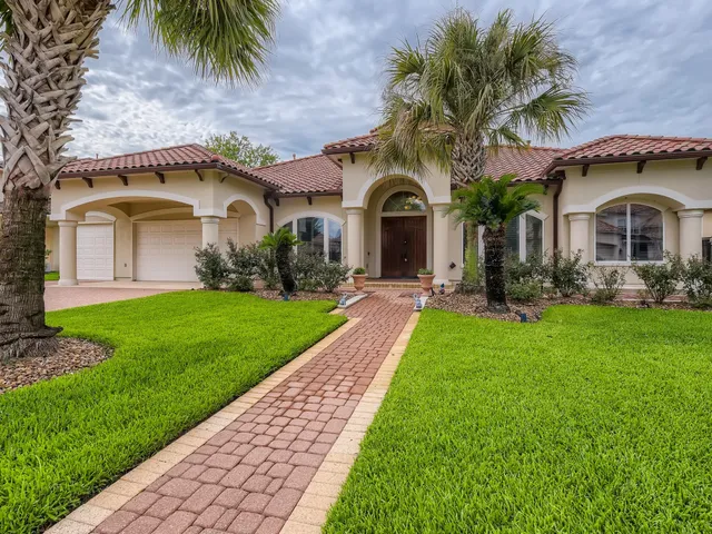 a front view of a house with a garden and plants