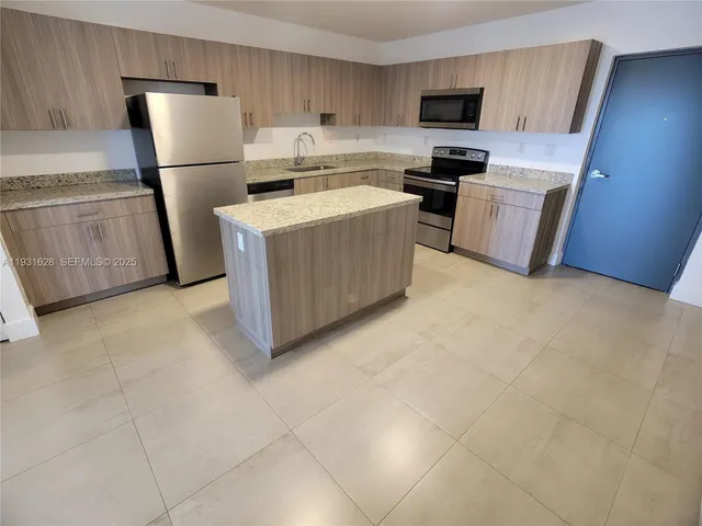a kitchen with a refrigerator a stove top oven a sink and dishwasher
